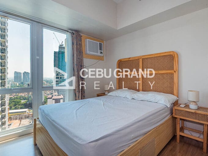 Living and dining area with the sleeping space beyond at the furnished studio for rent at Solinea Tower 2, Cebu Business Park