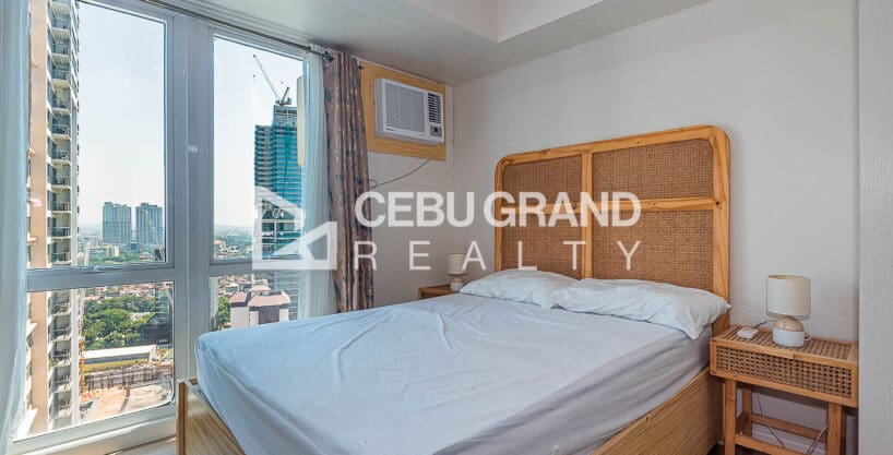 Living and dining area with the sleeping space beyond at the furnished studio for rent at Solinea Tower 2, Cebu Business Park