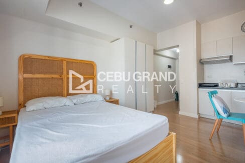 Sleeping area looking past the built-in wardrobe to the entry hall and kitchen at the studio for rent at Solinea Tower 2