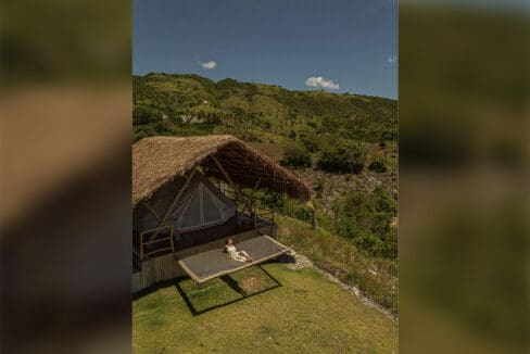 Aerial view of a glamping tent with loft hammock and hillside behind at the resort for sale in Oslob, Cebu