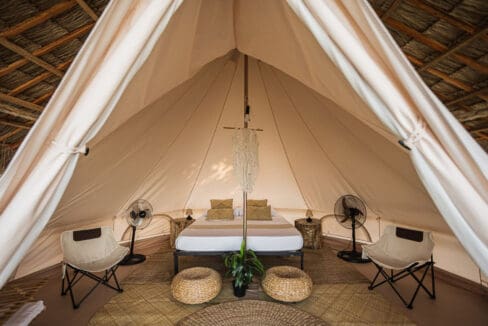 Interior of a canvas bell tent with double bed and woven rug at the resort for sale in Oslob, Cebu
