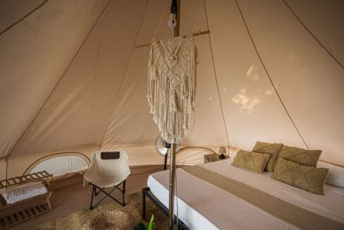 Bell tent interior detail with macrame hanging and cushioned bed at the resort for sale in Oslob, Cebu
