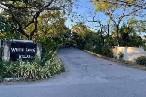Entrance signage and gated road into White Sands Villas subdivision, Maribago