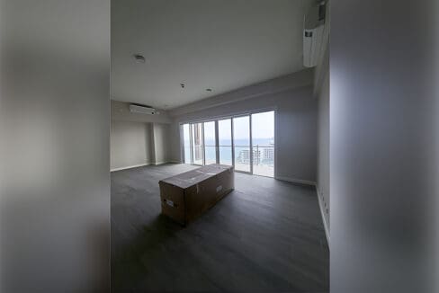 Open living and dining space with kitchen counter and wide windows