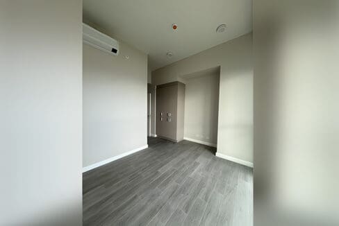 Unfurnished bedroom with wood flooring and white walls