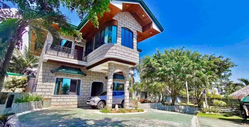 Two-storey stone-clad house with circular driveway and garden at the 6BR house and lot with pool for sale in Maghaway, Talisay