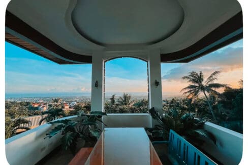 Covered balcony looking out to the sea at sunset at the 6BR house and lot for sale in Maghaway, Talisay