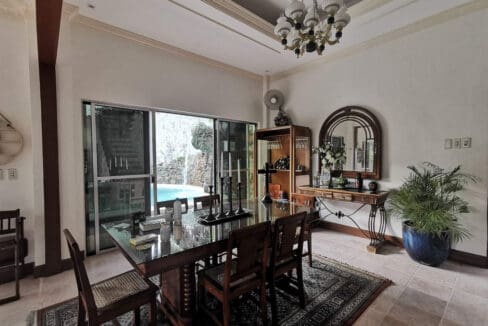 Dining area with chandelier and sliding doors to the pool at the house and lot for sale in Maghaway, Talisay