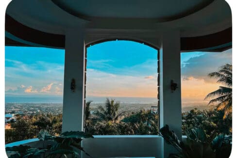 Sunset over the sea framed by the arched balcony at the house and lot for sale in Maghaway, Talisay