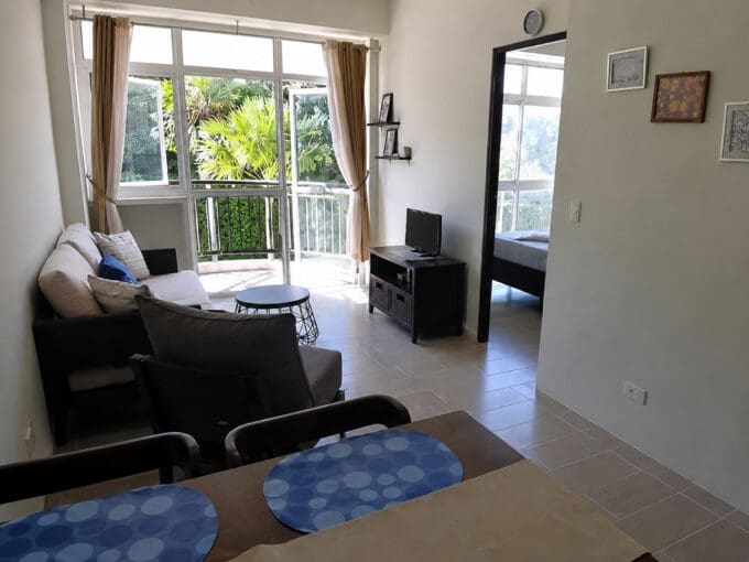 Living and dining area with sliding doors to the balcony at the furnished 1BR condo for sale in Boracay, Oceanway Residences