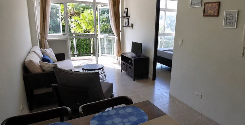 Living and dining area with sliding doors to the balcony at the furnished 1BR condo for sale in Boracay, Oceanway Residences