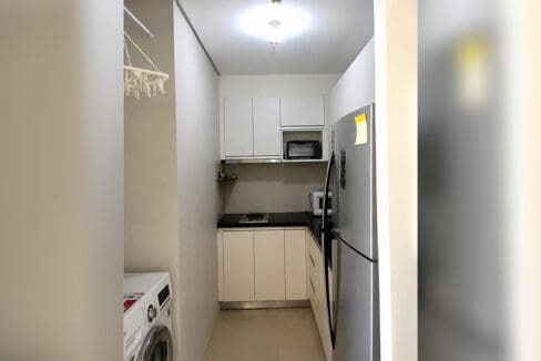 Galley kitchen with washing machine and drying rack at the furnished 1BR condo for sale in Boracay Newcoast