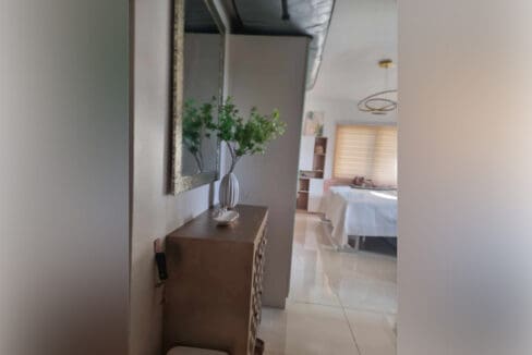 Entry area with console table and mirror looking into the furnished studio for sale in Mabolo, Cebu City