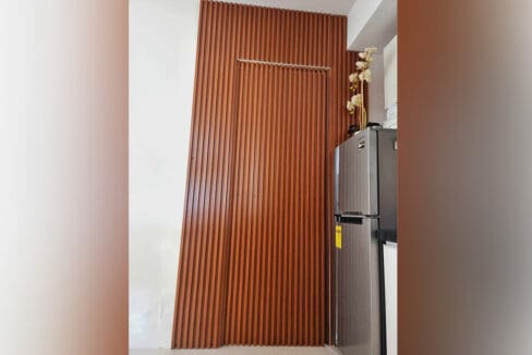 Slatted wood partition beside the refrigerator at the furnished studio for sale in Mabolo, Cebu City