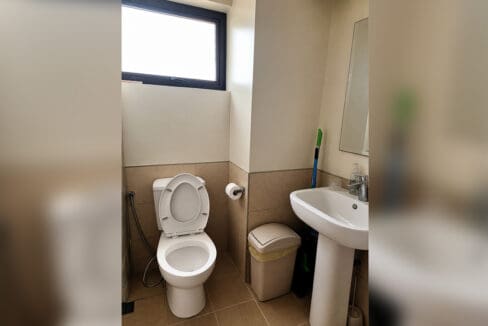 Bathroom with toilet, pedestal basin and window at the furnished studio for sale in Mabolo, Cebu City