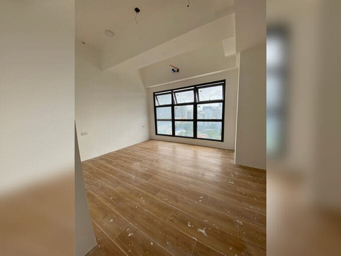 Studio living and sleeping area with a wide grid window and wood-plank tile at Vertex Central, Cebu City