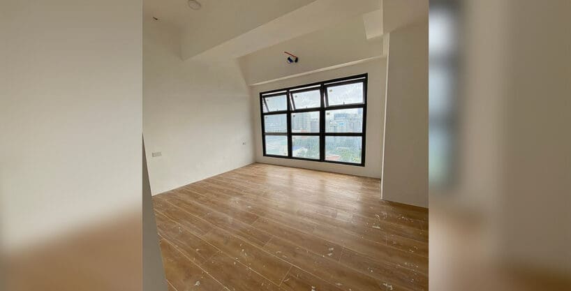 Studio living and sleeping area with a wide grid window and wood-plank tile at Vertex Central, Cebu City