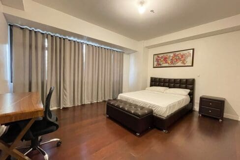 Bedroom with upholstered bed, storage bench and work desk