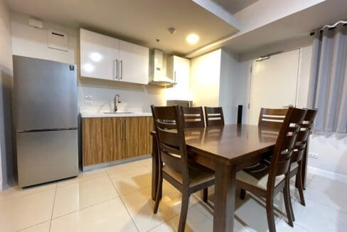 Kitchen with refrigerator, range hood and six-seater dining table