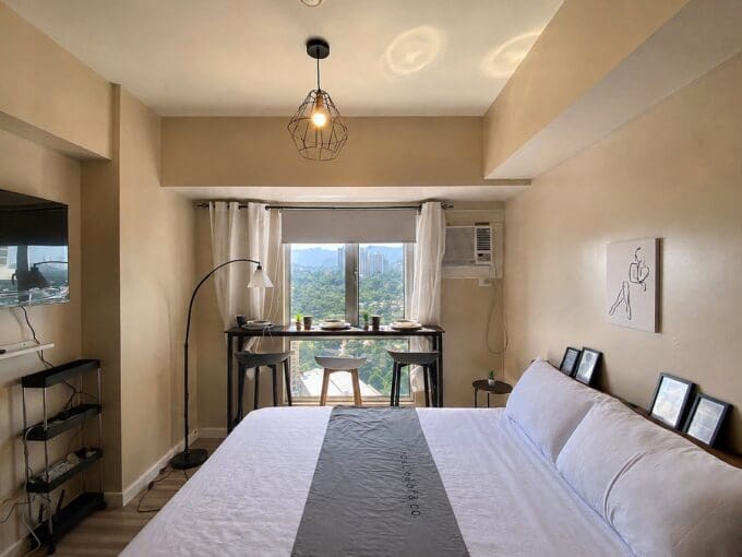Double bed facing the window bay with its bar-height table and stools at Avida Towers Riala, Cebu IT Park