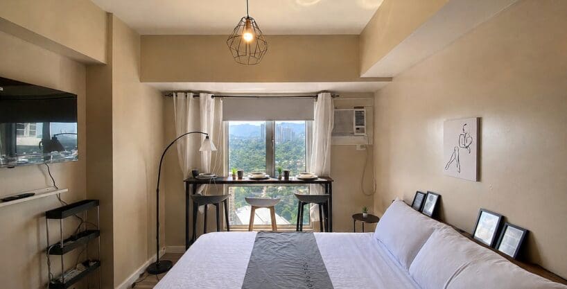 Double bed facing the window bay with its bar-height table and stools at Avida Towers Riala, Cebu IT Park