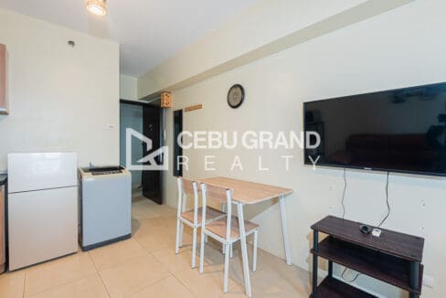 Dining table for two by the entry, with the refrigerator and washing machine in the kitchen corner