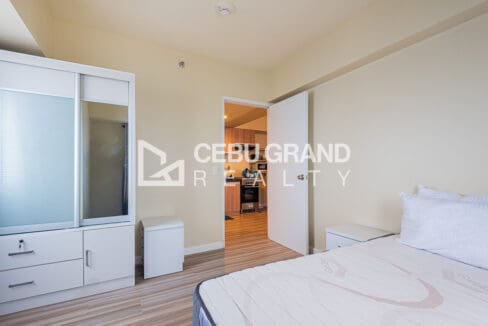 Mirrored sliding wardrobe in the bedroom, with the door open to the kitchen