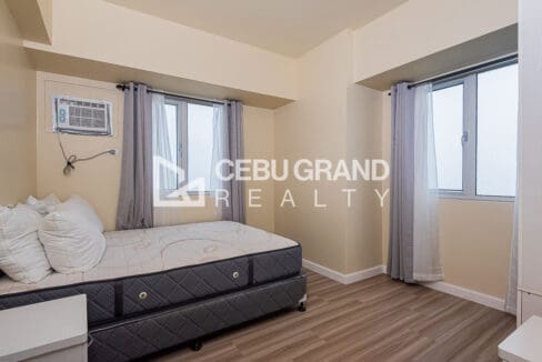 Bedroom with a double bed and windows on two sides of the corner unit