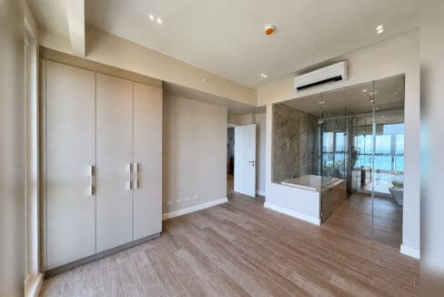 Master bedroom with fitted wardrobes and glass-enclosed ensuite