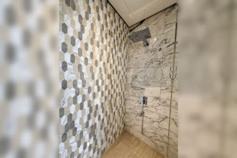 Walk-in shower with hexagon mosaic tile and rain head