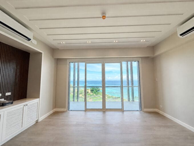 Living area with slatted timber feature wall and floor-to-ceiling sea view