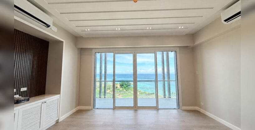 Living area with slatted timber feature wall and floor-to-ceiling sea view