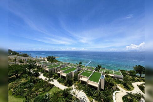 Aerial view of the beachfront villas and reef at Aruga Resort and Residences