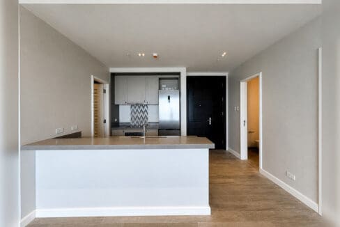 Kitchen peninsula with quartz counter beside the entry hall