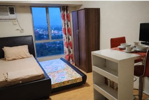 Single bed with its pull-out trundle extended beside a timber wardrobe and shelving unit