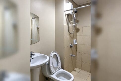 Bathroom with a pedestal basin, toilet and a tiled shower area with a water heater