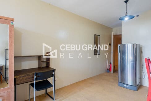 Study desk with shelving and the tall refrigerator beside the entry hallway