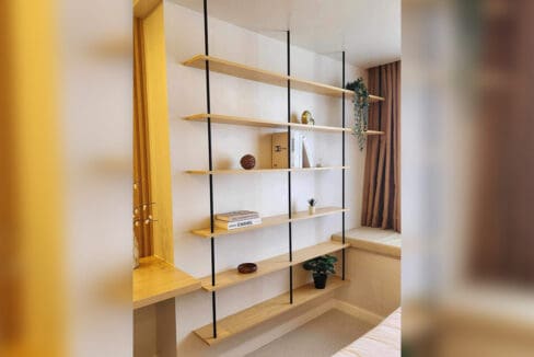 Open timber shelving beside the window nook in the furnished studio