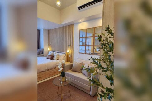 Sleeping and seating area with framed mirror in the furnished Mandani Bay Suites studio