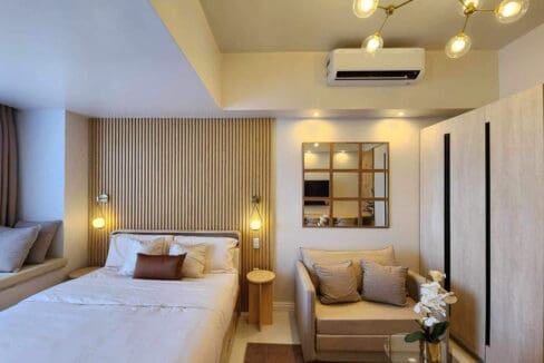 Studio interior with queen bed, sofa bed and full-height wardrobes