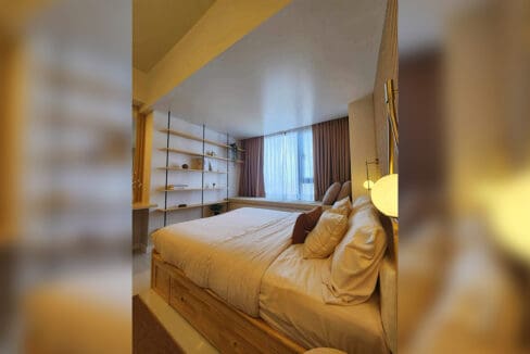 Bed with open shelving and the sea-facing window nook beyond