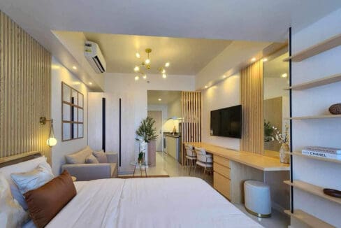 Full view of the 30 sqm studio showing the bed, sofa, workspace and kitchen