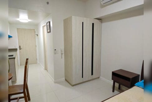Tall wardrobe, split-type air conditioning and entry door in a Mandani Bay studio