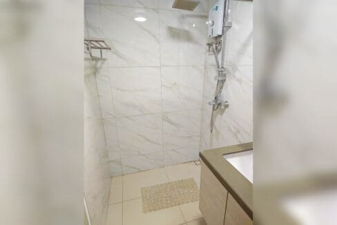 Walk-in shower with marble-look tiles, rain shower head and water heater