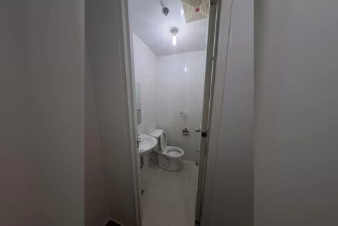 Second bathroom with a corner basin and toilet.