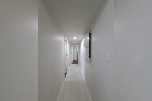 Hallway leading through to the hardwood-floored bedrooms.