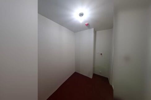 Small room off the hallway with dark hardwood flooring.