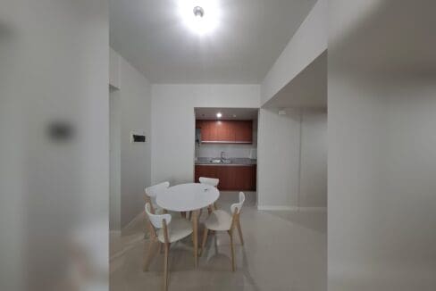 Dining area looking through to a timber kitchen with granite counters.