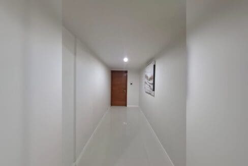 Corridor with gloss floor tiles leading to the bedrooms in a Lahug condo for rent.