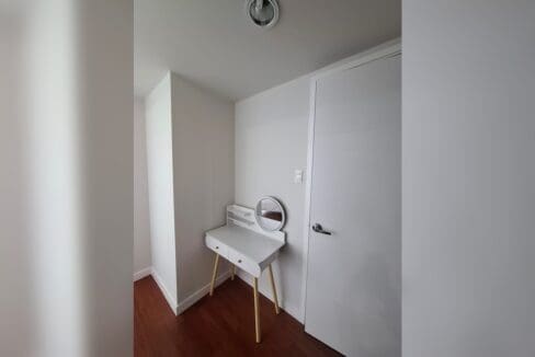 Vanity desk with a round mirror set in a bedroom nook.